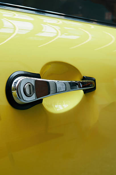 istock Yellow car door handle with a silver knob. Phone wallpaper. Vertical background. 2223910219