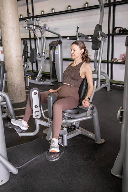 istock Woman Exercises on Leg Extension Machine at Modern Gym During Daytime Workout Session 2223910727