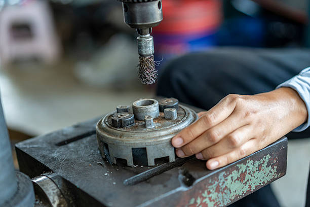 Close-up hands of a female technician using a drill press, emphasizing precision, technical skill, and women in industrial trades at work in a machine shop.
