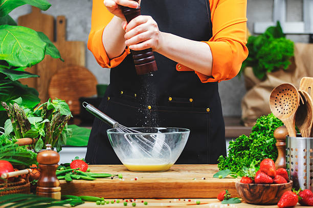 istock skilled chef grinds pepper in mill prepares healthy dish using fresh eggs and utensils in a bright and lively kitchen filled with greenery. 2223917533