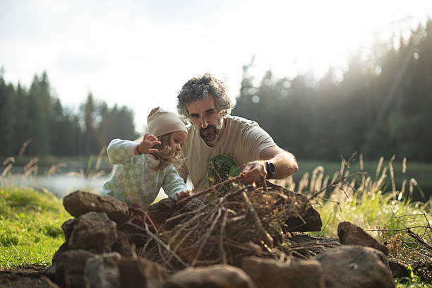 istock Dad & Daughter Preparing Campfire At Lakeshore 2223921611