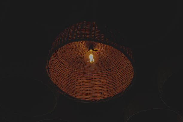 reddish colored lamp lit inside a wooden basket. Interior decoration