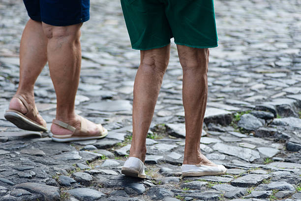 Half-length unidentified people walking on a cobblestone street during daytime. Pelourinho, Brazil.