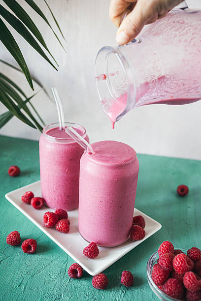 istock Two Homemade Raspberry Smoothies with One Being Poured  Fresh and Healthy Antioxidant Drink 2223923664