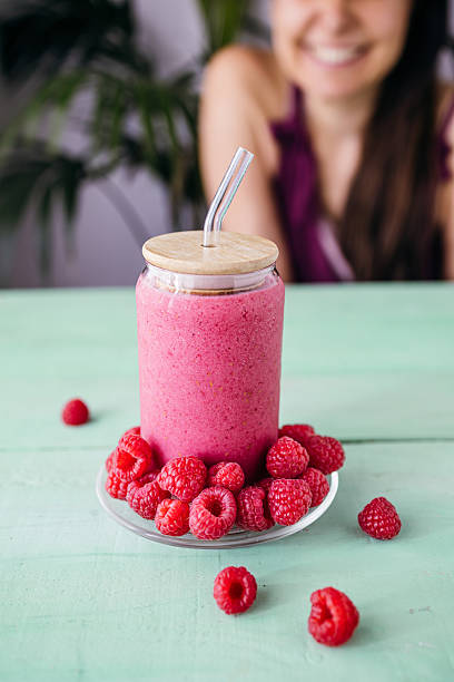 Raspberry Smoothie with Smiling Woman in the Background