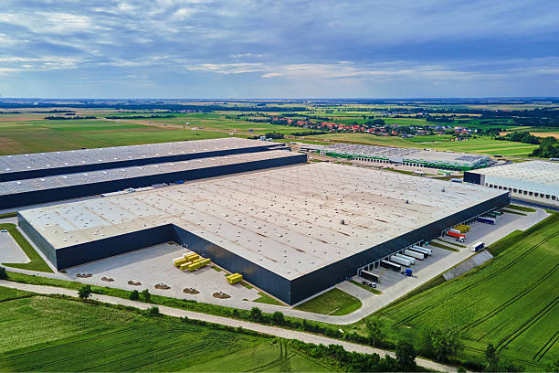Large modern warehouse with loading docks in green rural landscape