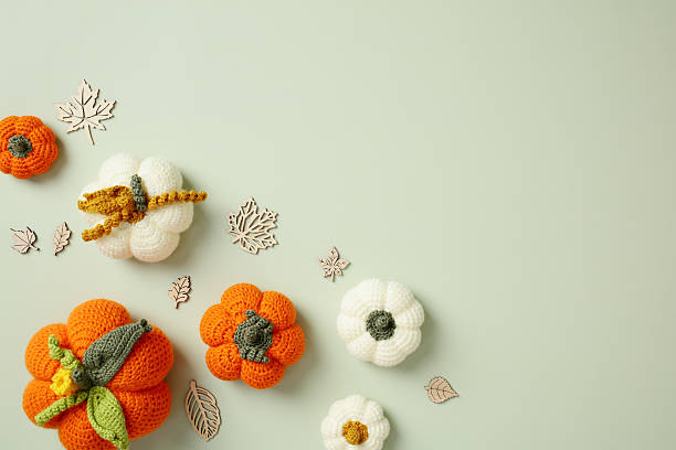 istock Handmade crocheted pumpkins with fall-themed decor on a soft green backdrop. Ideal for autumn crafts, cozy DIY projects, seasonal visuals, and rustic design concepts. 2223924498