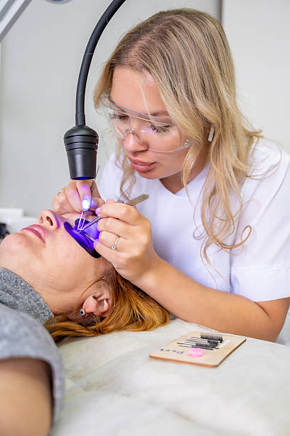 istock Eyelash extension procedure using ultraviolet lamp in modern beauty salon. Innovative lash enhancement technology with precise application technique. 2223926827