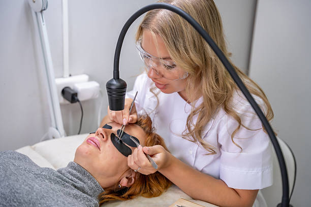 istock Eyelash extension procedure using ultraviolet lamp in modern beauty salon. Innovative lash enhancement technology with precise application technique. 2223926833