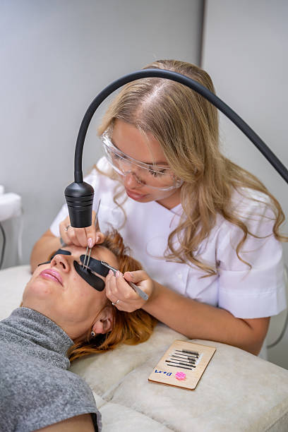 istock Eyelash extension procedure using ultraviolet lamp in modern beauty salon. Innovative lash enhancement technology with precise application technique. 2223926837