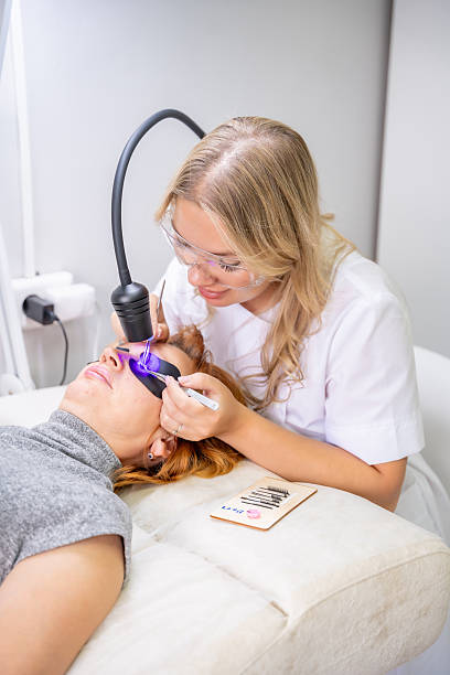 istock Eyelash extension procedure using ultraviolet lamp in modern beauty salon. Innovative lash enhancement technology with precise application technique. 2223926858