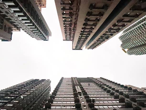 Mong kok, Hong Kong- May 10 2025: captivating view looking upward between tall buildings, creating a dramatic perspective. The structures, characterized by a mix of modern glass facades