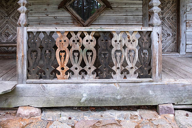 Old log house with carved railings. Architectural element.