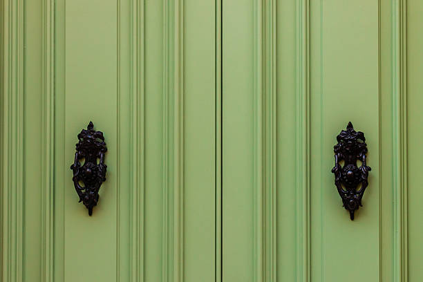 istock Elegant Green Double Door with Ornate Black Handle Knockers 2223931170