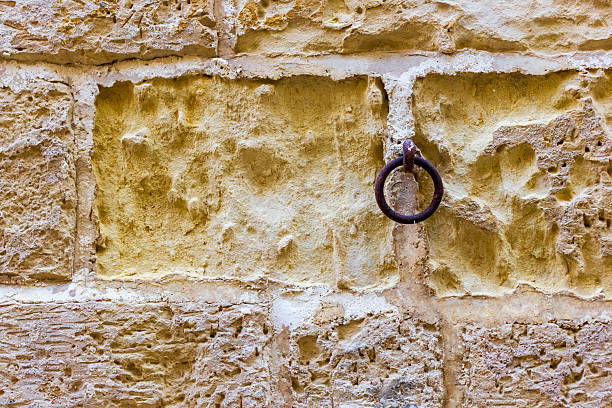 Old rusty door handle on a stone wall, closeup of photo