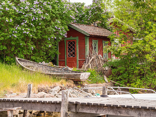 istock Rustic Red Cabin by the Water with Lush Greenery 2223931342