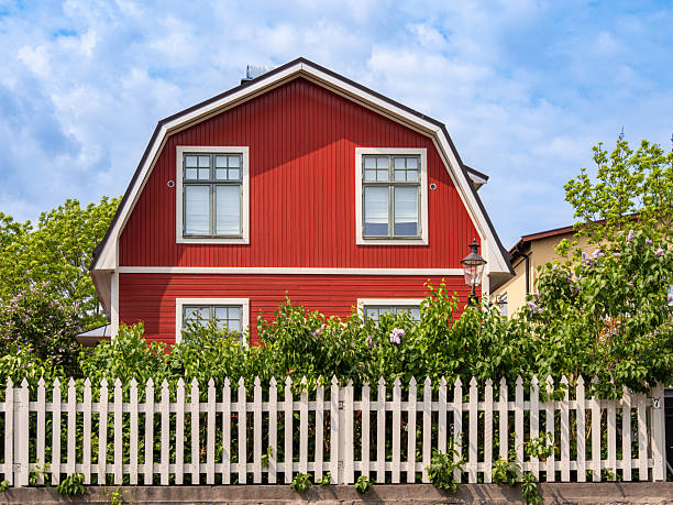 picturesque white house with red roof and well-maintained lawn.