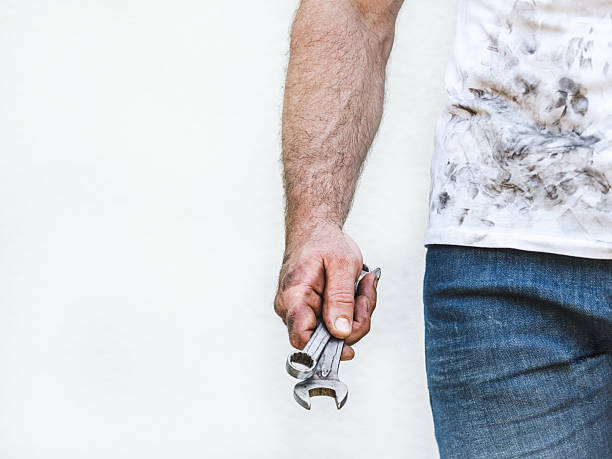 Attractive man, hand tools and dirty shirt. Labor day. Front view, close up, studio shot. Labor and employment concept
