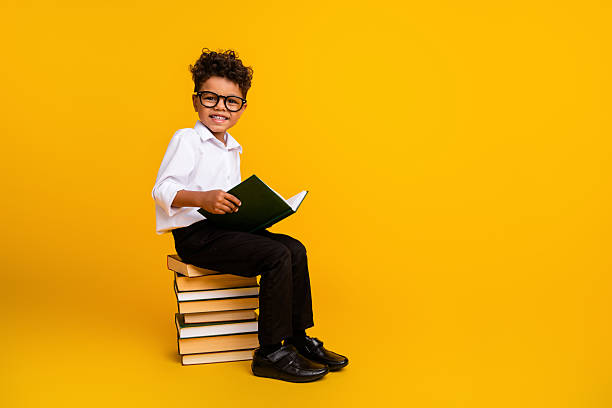 istock Full body profile portrait of smart positive boy sit pile stack book read empty space ad isolated on yellow color background 2223933722