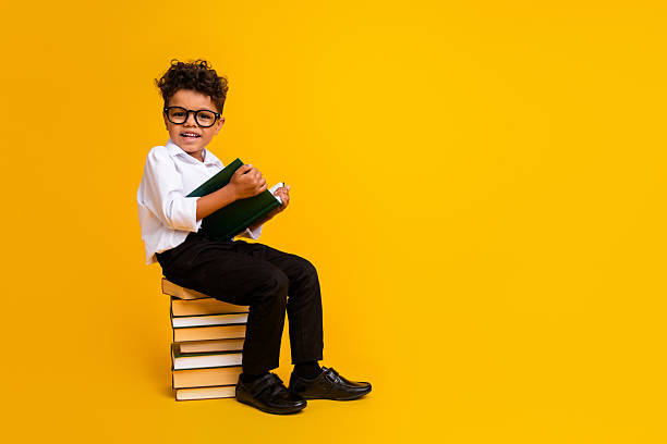 istock Full length profile photo of smart diligent boy sit pile stack book read empty space offer ad isolated on yellow color background 2223933723