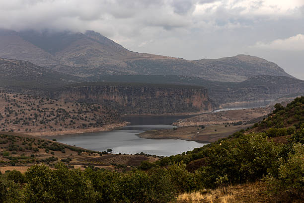 A scenic view of the Atatürk Dam, one of Turkey’s largest reservoirs, surrounded by dramatic hills and cloudy skies in Southeastern Anatolia.