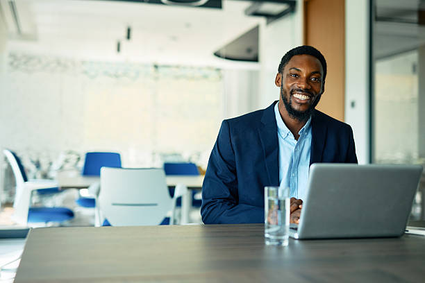 istock Smiling businessman working on laptop in modern office 2223934494