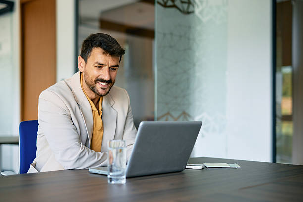 istock Businessman smiling and working with laptop in modern office 2223934514