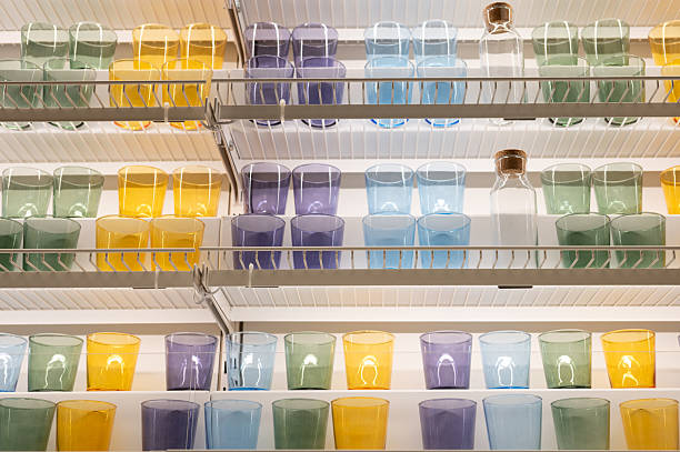 Colorful glasses and bottles arranged on shelves in a pantry setting.
