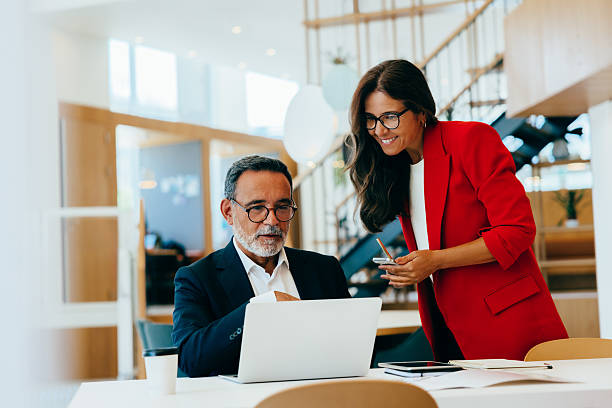 istock Senior professionals discussing project details at a laptop in an office setting 2223939202