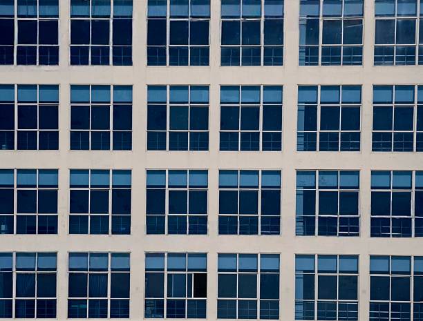 istock Symmetrical grid of blue glass window on office building 2223941443