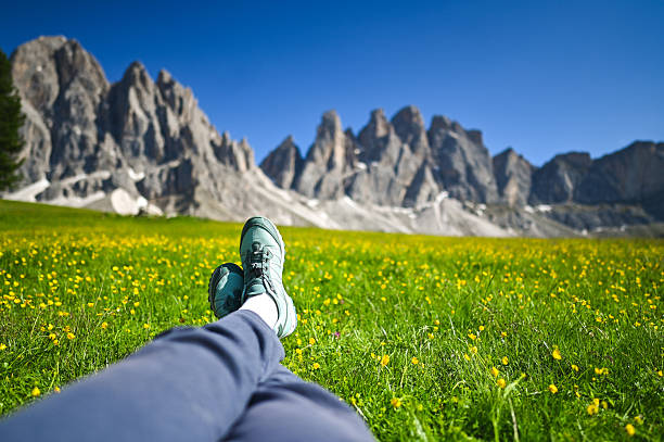 Hiker relaxing in a meadow enjoying the dolomites view