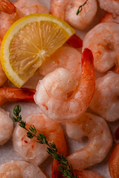 istock Frozen uncooked prawns or shrimps with lemon 2223954327