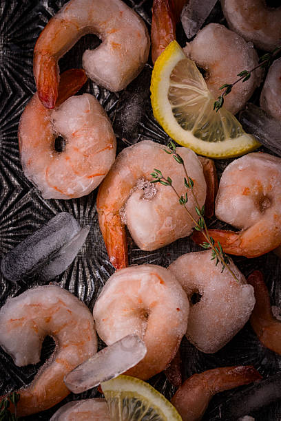 istock Frozen uncooked prawns or shrimps with lemon 2223954372