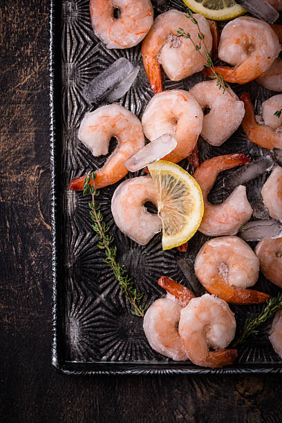istock Frozen uncooked prawns or shrimps with lemon 2223954400