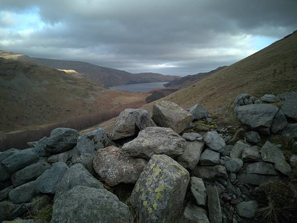 A single track road snakes between the mountains of the Lake District between Braithwaite and Buttermere on a moody day