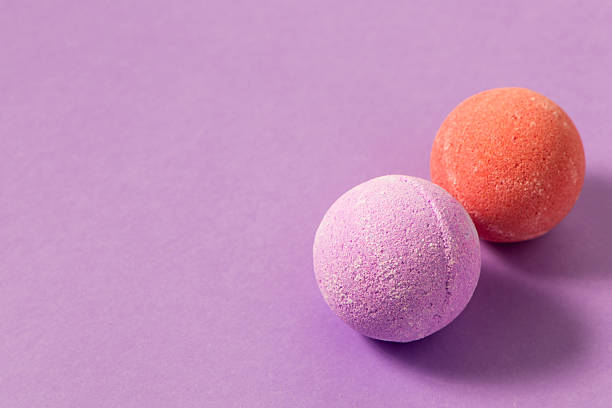 istock Colorful bath bombs placed on a light purple surface during a relaxing spa moment 2223963274