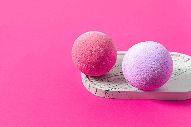 istock Colorful bath bombs resting on a stylish tray against a vibrant pink backdrop 2223963283