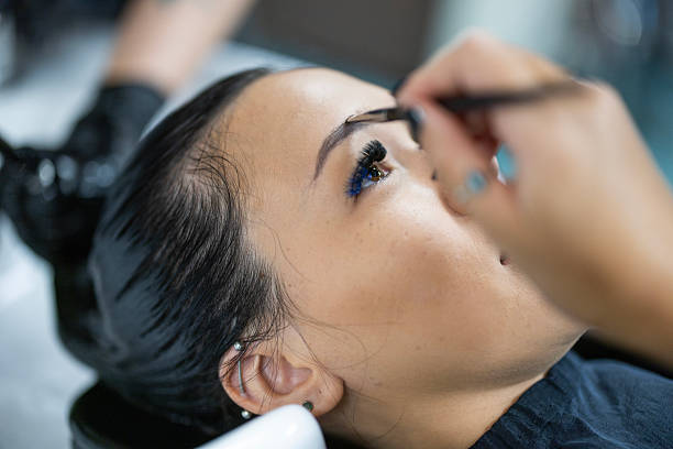 a woman getting her hair washed and makeup done at a hair salon.