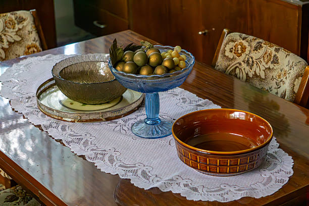 Retro dining table with a lace runner, glass and ceramic bowls, and decorative fruits – classic interior from the communist era.