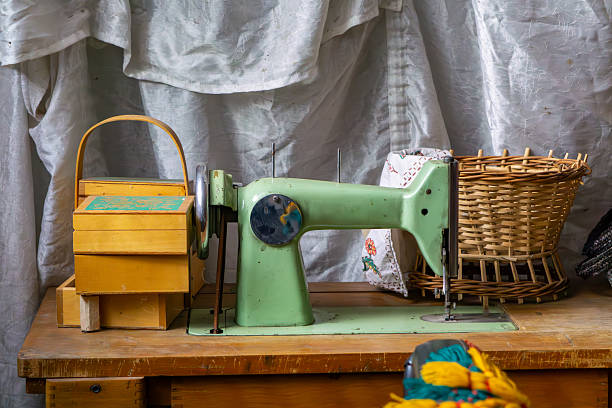 istock Vintage sewing table with an old sewing machine, wooden thread box, and wicker basket – a glimpse into a traditional home workshop. 2223967307