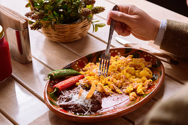 istock Unrecognizable man eating scrambled eggs with ham and beans with cheese and beet juice 2223968003