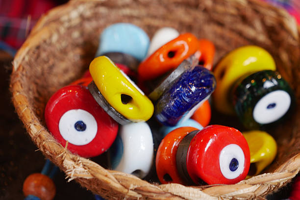 Vibrant, handmade ceramic beads are displayed in a woven basket.