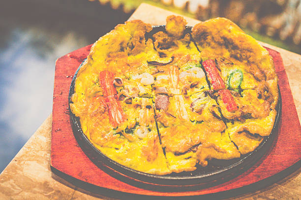 korean seafood pancake served on cast iron grill on a table