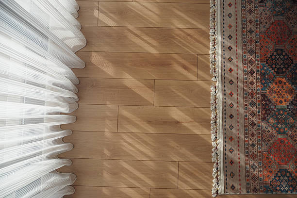 istock Warm sunlight streaming through sheer curtains onto wooden floor 2223970820