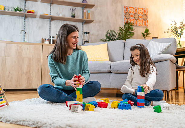 istock Mother and daughter building with blocks at home 2223975893