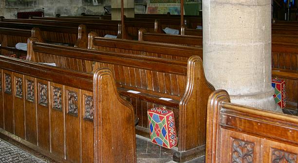 Rows of wooden pew seats with decorative end panels