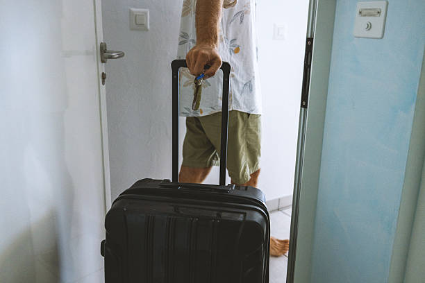 istock Man Entering Room with Black Rolling Suitcase 2223988224