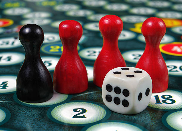 istock colorful play figures with dice on board 2223993968