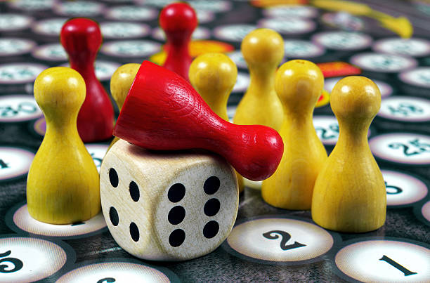 istock colorful play figures with dice on board 2223995042