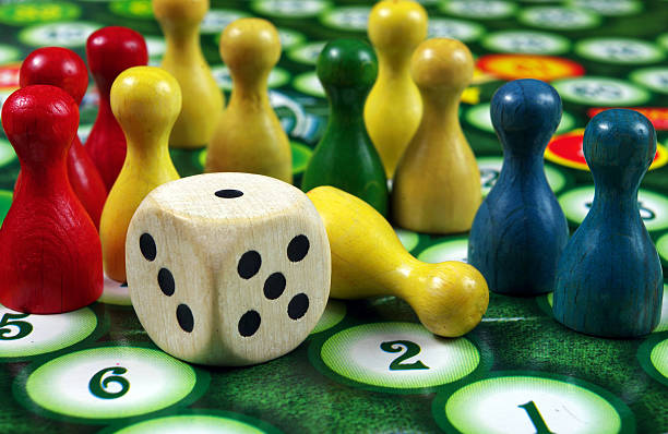 istock colorful play figures with dice on board 2223995043